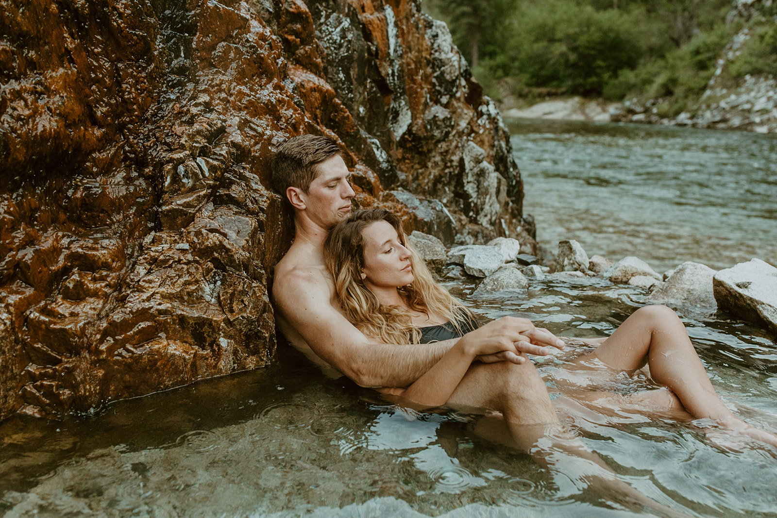 idaho hot spring engagement session photos with a couple laying down in the hot springs